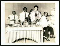 C.C. Pinkston posing with drums and his band