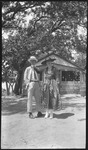 Two people in front of a small shack