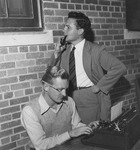 Two students posing as newspaper columnist and editor