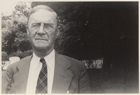 Man wearing glasses poses in front of trees