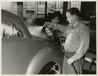 Man spray painting the exterior of an automobile