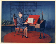 Woman displays sketch of palm tree at drawing desk