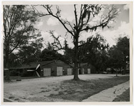 Two hangars with a three blade aircraft propeller outside