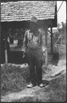 Man in hat standing in front of carport