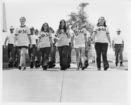 Several sorority members marching with one carrying a UH flag