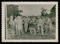 Men gathered around Jeep, evacuation of POWs