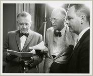 Dr. Hubertus Strughold, Paige Keetan, and Dr. John Meaney gather around a script