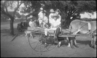 Group of people on two-wheeled cart