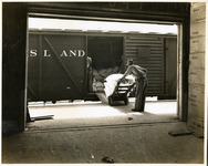 Man loading freight onto rail car
