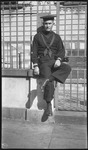 Man in sailor's uniform in front of a gate