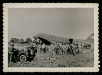Men gathered next to plane, evacuation of POWs