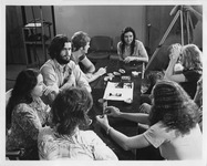 Students sitting around table discussing a film project