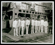 Group of officers standing beneath gun