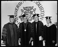 President Philip G. Hoffman with Alfred Neumann and two other men at a commencement ceremony