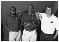 Clyde Drexler standing with two assistant coaches