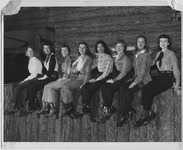 Students sit on a wooden ledge