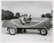 Man adjusting the steering wheel of a miniature car