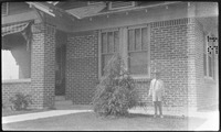Boy standing in front of brick house