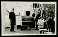 Capt. Guy Baker accepts the piano for the ship