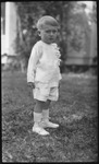 Young boy standing in front yard