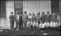 Group of men and woman in front of building