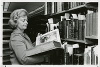 Woman standing in front of bookshelf