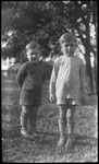 Two boys standing in yard