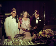 Group of people in formal attire standing behind a table