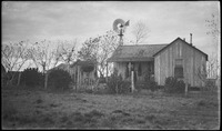 Men in front of house with windmill