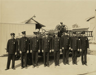 Group photo of Station 24 firefighters standing in front of fire engine