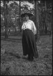 Woman facing camera in a wooded area