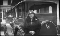 Woman standing in front of car