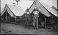 Two sailors in front of tents