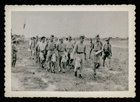 Men walking through field, evacuation of POWs