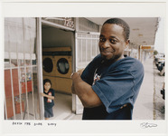 Devin the Dude posing outside a laundromat