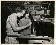 Two women working with a drill press