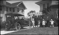 Family posing in front of a house 