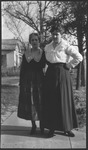 Two women standing on a sidewalk