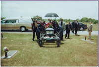 Pallbearers and cemetery employees move Fat Pat's casket from hearse to plot