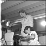 Dorothy Sinclair looks over student's desk