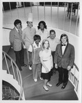 Hotel management staff posing on a staircase