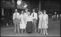 Group of people posing in front of plants