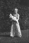 Girl wearing dress and holding doll