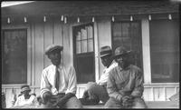 Group of people sitting in front of house