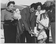 Small boy in costume shaking hands with students