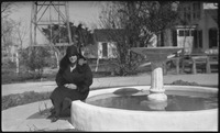 Woman sitting next to fountain