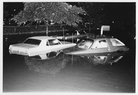 Cars halfway submerged in a flooded parking lot