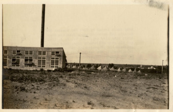 Army tents loaned by Fort Sam Houston behind a building