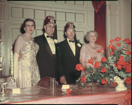 Group of people in formal attire with roses