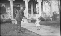 Man and child in front of a house